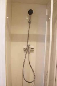 a shower with a shower head in a bathroom at Studio boisé à 2 pas du jardin du Luxembourg in Paris