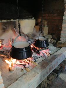 dos ollas colgando sobre un fuego en una chimenea en Apartman Kalinka, en Gajić
