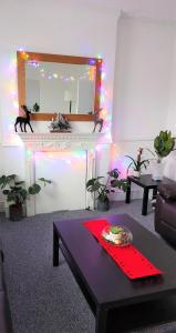 a living room with a fireplace with a mirror and a table at Very spacious two bedroom converted apartment in East Croydon in Croydon