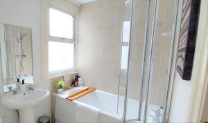 a bathroom with a shower and a tub and a sink at Very spacious two bedroom converted apartment in East Croydon in Croydon