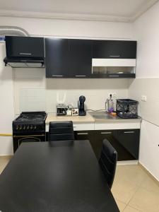a kitchen with black cabinets and a black counter top at Luxury Studio in Bucharest +3 photos