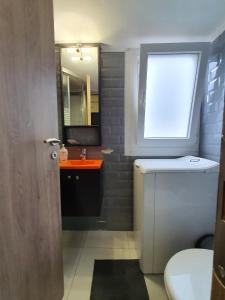 a bathroom with a sink and a window and a toilet at Cozy Little Home in Athens