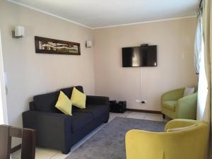 Una sala de estar con un sofá azul y un televisor. en Casa arriendo Pucon, en Pucón