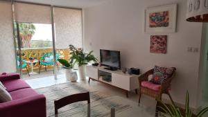 巴哈馬爾的住宿－Apartamento en Bajamar -Tenerife，客厅配有紫色沙发和电视