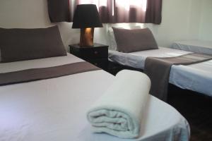 Pokój hotelowy z 2 łóżkami i ręcznikiem na krześle w obiekcie VALUE PLACE w mieście Wadi Musa