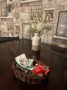 a basket of snacks on a table with a vase at Bright Apartments in Peterborough