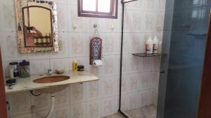 a bathroom with a sink and a shower with a mirror at Casan Duplex em Saquarema in Saquarema +32 photos