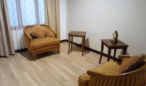 uma sala de estar com duas cadeiras e uma mesa em Hotel El Conquistador em Cuenca