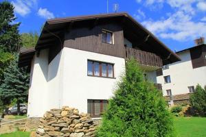 a house with a pile of rocks in front of it at Apartmany U Ády in Železná Ruda