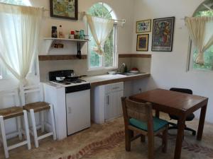 a kitchen with a table and a stove and a sink at Casa del Arquitecto in Cancún
