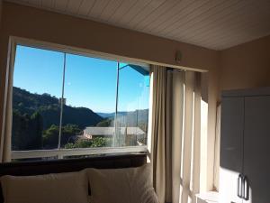 a large window with a view of a mountain at Apartamentos Zidane in Gramado