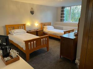 
a hotel room with two beds and a desk at Shandwick House in Tain
