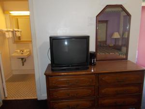 TV en la parte superior de un tocador con espejo en Hillside Motel, en Homer 41 fotos más