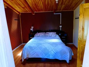 - une chambre avec un lit et une couette bleue dans l'établissement Cabaña Amoblada Full en Rio Bueno, à Río Bueno