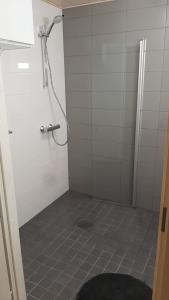 een badkamer met een douche en een tegelvloer bij Lehtikatu Apartments in Rovaniemi