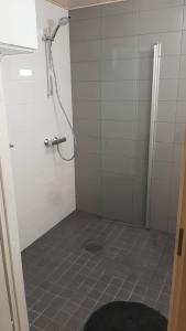 y baño con ducha y suelo de baldosa. en Lehtikatu Apartments, en Rovaniemi
