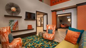 a living room with two chairs and a couch at Best Western Premier Ashton Suites - Willowbrook in Houston