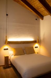 a bedroom with a white bed with two pillows at Domus Oncinae in Oncina de la Valdoncina
