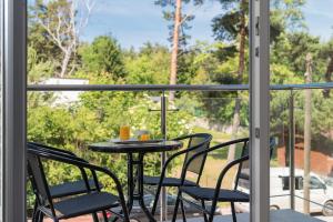 a table and chairs on a balcony with a view at Aparthotel Luna&Sol in Jastrzębia Góra