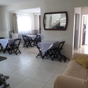 a living room with tables and chairs and a mirror at Mariba's Pousada in João Pessoa