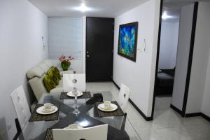 a living room with a table and a couch at Aparta hotel; Guduales del Cafe. in Montenegro
