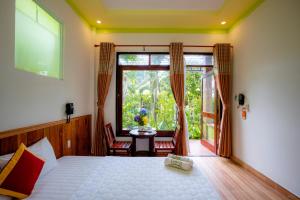 ein Schlafzimmer mit einem Bett und einem großen Fenster in der Unterkunft Mai Binh Phuong Bungalow in Phu Quoc