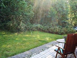 a wooden deck with a table and a chair at 5 person holiday home in HEN N in Henån