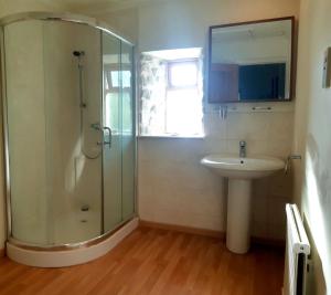 a bathroom with a shower and a sink at Plough Cottage is a 18th Century barn conversion offering a tranquil rural retreat 9 miles from the Lake District National Park in Carnforth