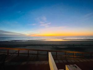 a view of the ocean at sunset from a balcony at Quinta Pacifica Beachfront Villas in Rosarito