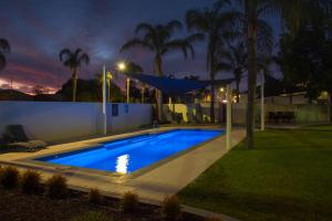 a swimming pool in a backyard at night at Hotel Renmark in Renmark