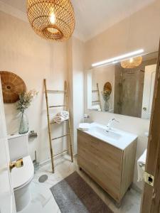 a bathroom with a sink and a toilet and a mirror at Casa del Sol - with Home Office space in Playa de San Juan +15 photos