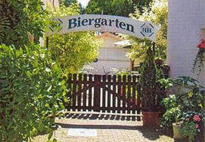 un banco de madera con un letrero para un jardín en Gasthaus Zum Rothenberg, en Lemberg