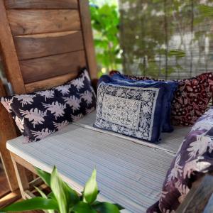 a bench with pillows sitting on a porch at Harry's Ocean House Pacitan in Pacitan