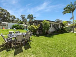 einen Tisch und Stühle im Hof eines Hauses in der Unterkunft Bikini Bottoms by Experience Jervis Bay in Huskisson