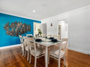 a dining room with a white table and chairs at Bikini Bottoms by Experience Jervis Bay in Huskisson