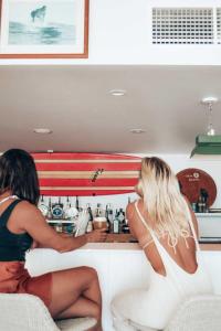 two women sitting on a toilet in a bathroom at The Surf House in Byron Bay