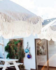 バイロンベイにあるThe Surf Houseのテーブル付きの部屋の白い天蓋