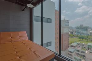a room with a couch in front of a window at Calligraphy Greenway Hotel in Taichung