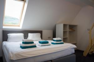 a bed with blue and white towels on it at Villa Kiwi in Mikulov