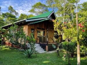 a small wooden cabin with a green roof at Villa Mango - Private Pool - 12px in Cahuita