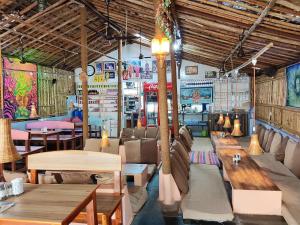 a restaurant with wooden tables and benches in a room at TEMPLE VIEW GUEST HOUSE in Hampi