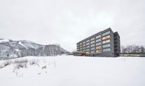 un edificio en la nieve frente a un campo en Hinode Hills Niseko Village, en Niseko