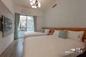 a bedroom with two beds and a large window at SunShine B&B in Taitung City