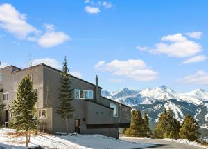 a house in the snow with mountains in the background at Gold Point Resort Breckenridge by Vacatia in Breckenridge