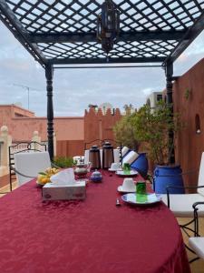 une table avec un tissu de table rouge sur une terrasse dans l'établissement Riad Amegrad, à Marrakech