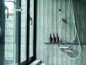 a bathroom with a shower with two bottles on a shelf at Rakuten STAY VILLA Hakone Sengokuhara North Wing 104 BBQ Terrace with Massage Chair capacity of 10 persons in Hakone