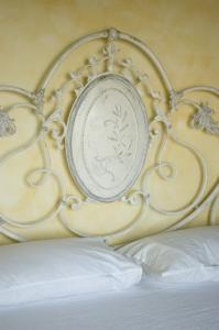 a white bed frame with a plate on it at Country House Il Sassòne in Camerano