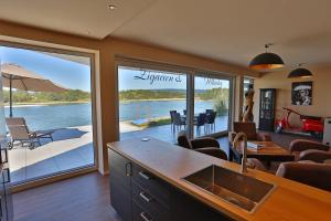 a kitchen and living room with a view of the water at Rhein Lounge in Urmitz