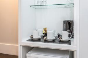 a cupboard with cups and saucers on it at Kingsford Smith Motel in Brisbane
