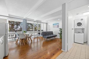 a kitchen and living room with a table and chairs at The Harrington Serviced Apartments in Narooma